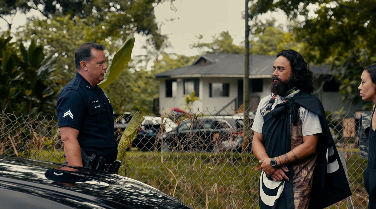 A man and women in stand outside talking to a police officer
