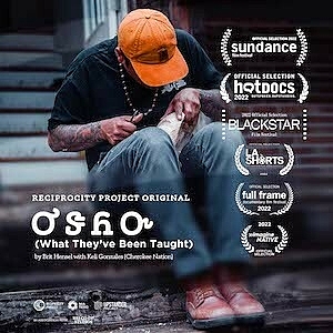 A man carves a mask while sitting on steps