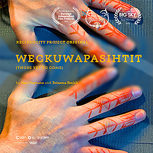 A portrait of a persons hands with red tattoo across the fingers