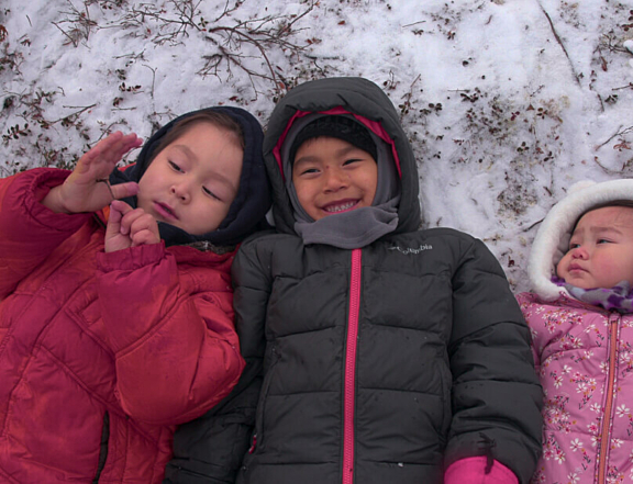 Photo of children laying in the snow