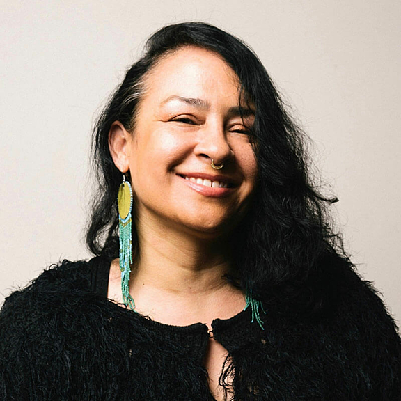 Portrait of women in black shirt and beaded earrings smiling