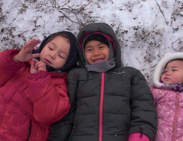 Photo of children laying in the snow