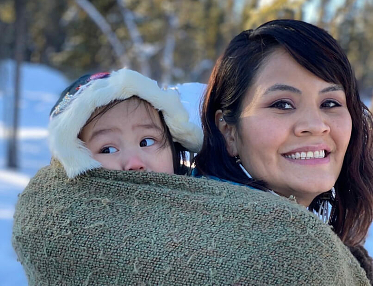 Woman with child in tow on her back